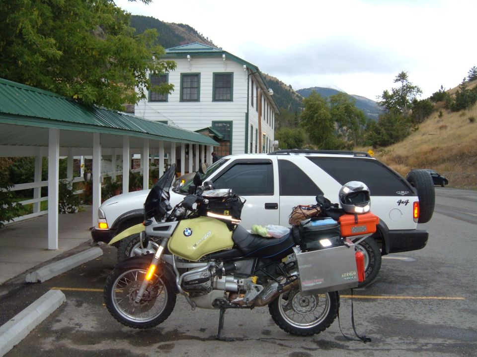Yellow BMW R1100GS motorcycle parked next to a white SUV.