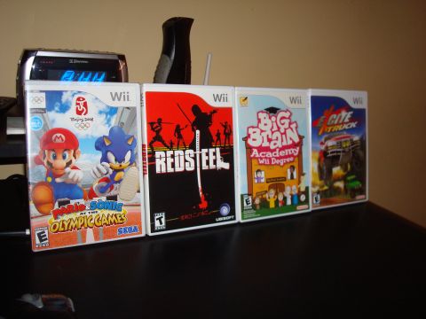 1992 Ford Bronco - A collection of Nintendo Wii game cases are displayed on a shelf, titles like Mario & Sonic at the Olympic Games and Excite Truck.
