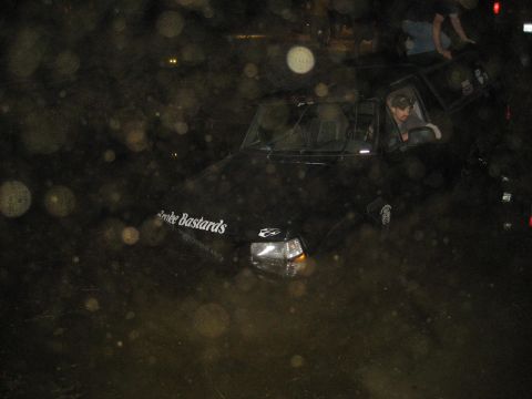 1995 Ford Bronco - A black SUV navigates through muddy terrain at night, with a driver visible inside.