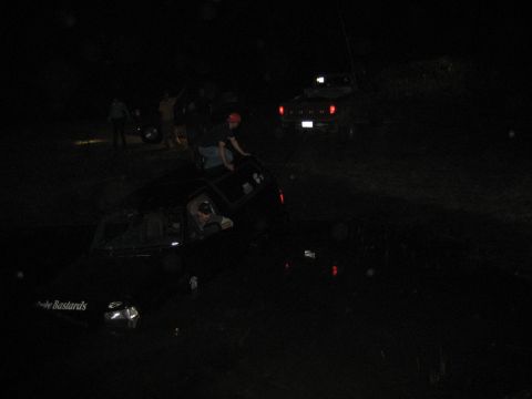 1995 Ford Bronco - Multiple vehicles are visible in a muddy scene at night, with one vehicle appearing stuck.