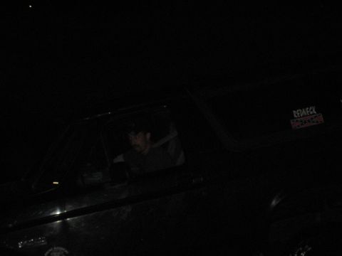 1995 Ford Bronco - Dark interior shot of a person in a vehicle at night with a 'Redneck' sticker visible.