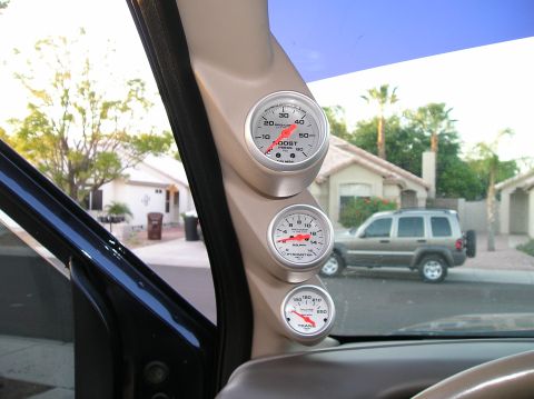 2001 Ford F-350 - Interior view showing boost, pyrometer, and transmission gauges with a Jeep Liberty visible through the window.