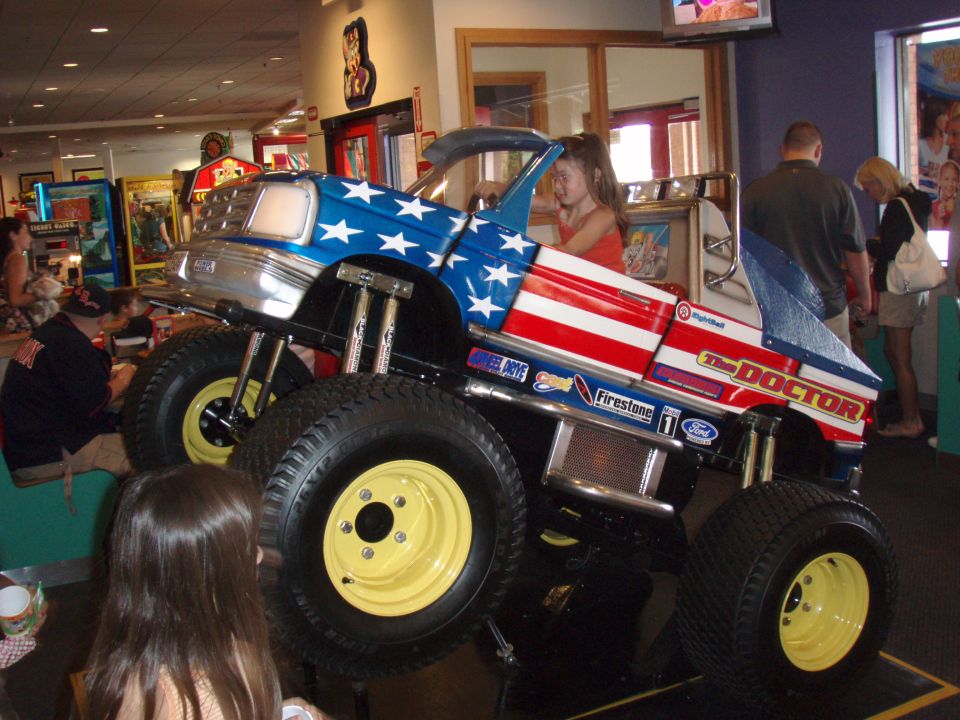 Toy monster truck ride with American flag paint, large yellow wheels, and 'The Doctor' text