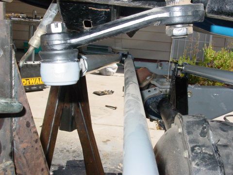 1979 Ford Bronco - Close-up view of vehicle suspension parts being worked on, supported by jack stands.
