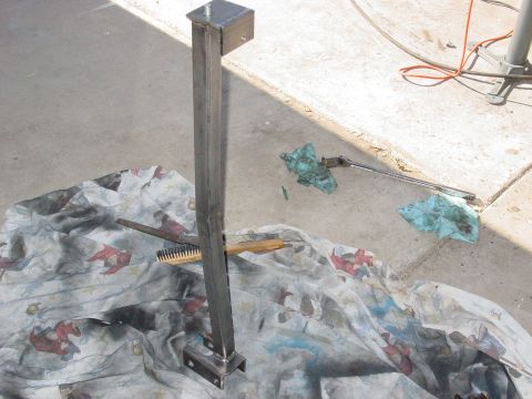 1979 Ford Bronco - A metal bracket assembly rests on a patterned cloth next to tools and rags.
