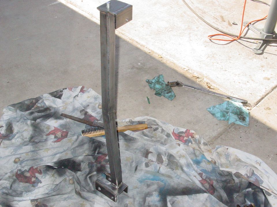 Metal bracket with bolts on a patterned cloth with a brush and oily rags