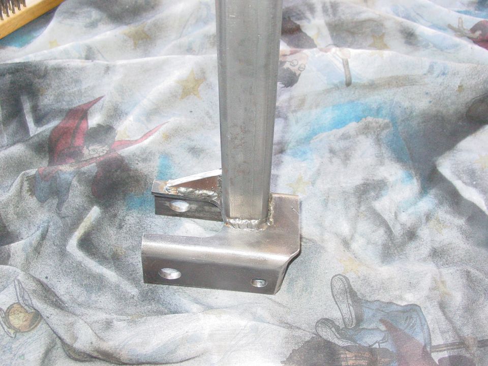 Fabricated metal suspension part with welded brackets and mounting holes