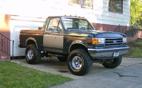 1990 Ford Bronco - This Ford Bronco has a two-tone paint scheme and is lifted with large off-road tires.