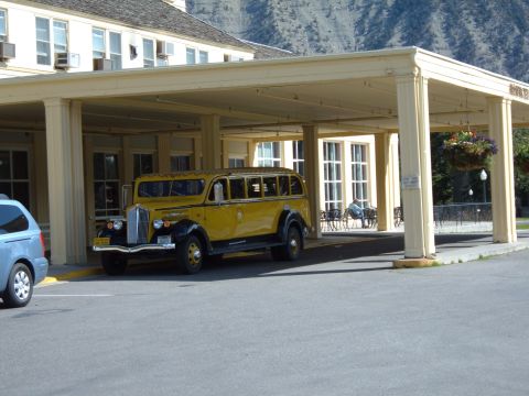 1998 BMW R1100GS ABS - A vintage yellow bus is parked under a covered walkway in front of a building.