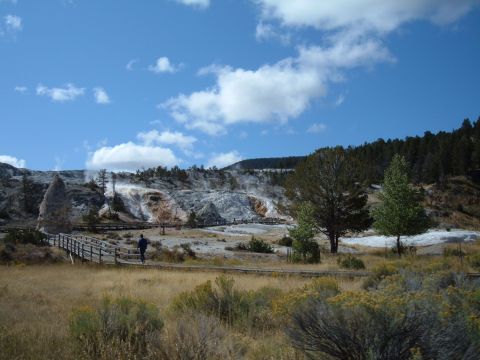 1998 BMW R1100GS ABS - A person walks on a boardwalk near geothermal hot springs and mineral deposits on a sunny day.