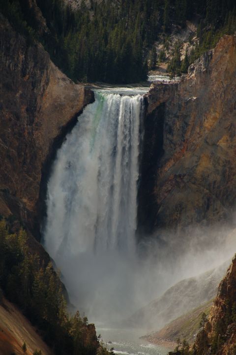 1998 BMW R1100GS ABS - A powerful waterfall plunges into a gorge, surrounded by cliffs and dense forest.