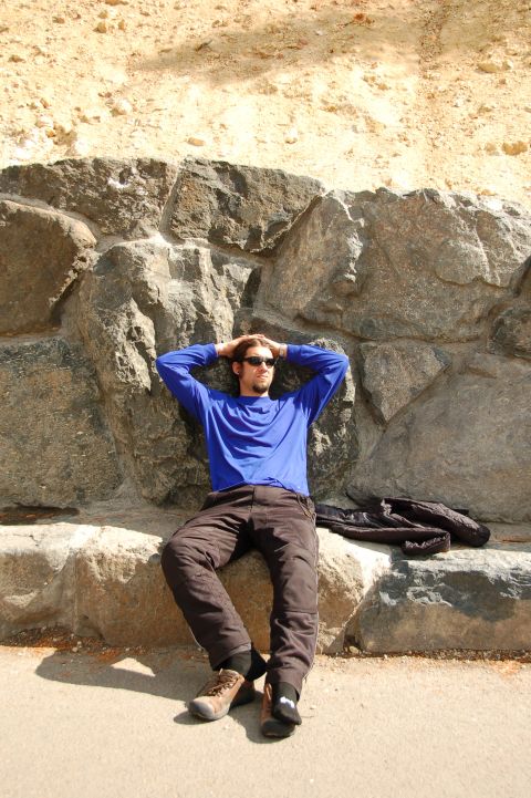 1998 BMW R1100GS ABS - Man rests against a large rock formation outdoors.
