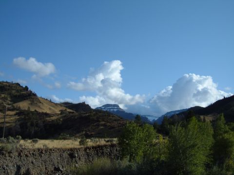 1998 BMW R1100GS ABS - A scenic view of mountains and clouds, with dry hills and trees in the foreground.