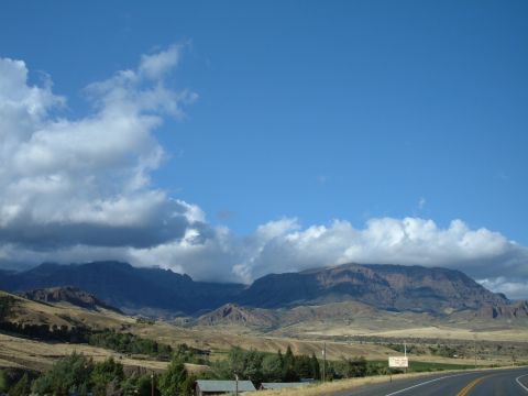 1998 BMW R1100GS ABS - A scenic view of mountains under a cloudy sky, with a road and a sign visible in the foreground.
