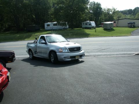 2001 Mercury Grand Marquis - Silver Ford F-150 SVT Lightning pickup truck seen at a car show with other vehicles present.