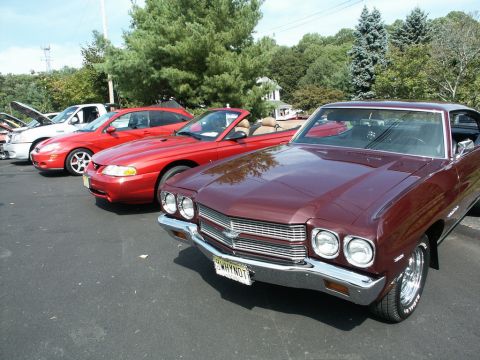 2001 Mercury Grand Marquis - Several vehicles are lined up at an outdoor car show, including a maroon coupe and a red convertible.