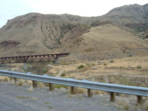 1998 BMW R1100GS ABS - A bridge spans a river in a dry, hilly landscape.