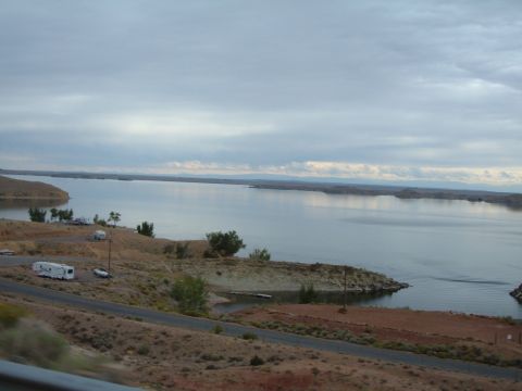 1998 BMW R1100GS ABS - A scenic view of a lake with a few vehicles parked along the shore under a cloudy sky.