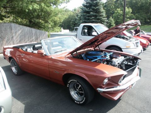 2001 Mercury Grand Marquis - A classic 1969 Ford Mustang convertible is displayed with its hood up at a car show.