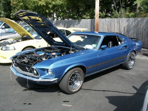 2001 Mercury Grand Marquis - A blue 1969 Ford Mustang Mach 1 is displayed with its hood open, alongside another Mustang.
