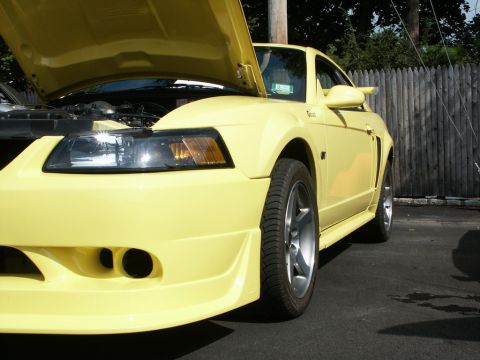 2001 Mercury Grand Marquis - Front view of a yellow Ford Mustang with the hood up.