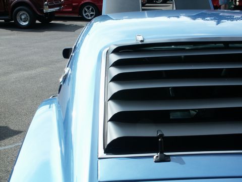 2001 Mercury Grand Marquis - Rear window louvers on a blue car at a car show with other vehicles present.
