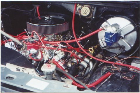 1986 Ford Bronco - Close-up view of a vehicle's engine compartment, a prominent air filter and red wiring.