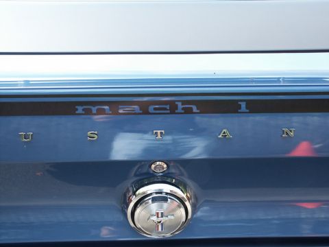 2001 Mercury Grand Marquis - The rear of a blue vehicle displays "mach 1" and "mustang" badging.