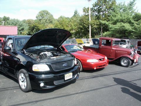 2001 Mercury Grand Marquis - Multiple vehicles on display at a car show, including a black Ford F-150 Lightning.