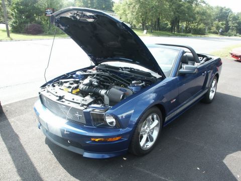 2001 Mercury Grand Marquis - A blue convertible with its hood open, revealing the engine bay and chrome wheels.