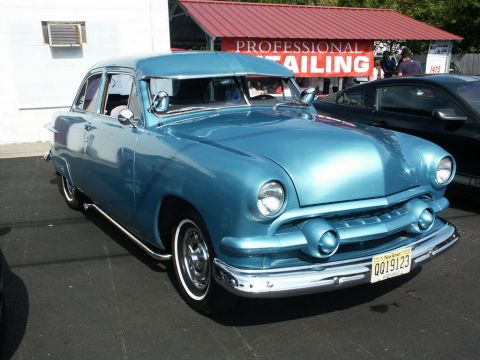 2001 Mercury Grand Marquis - Classic blue sedan parked at a car show with a "Professional Detailing" banner in the background.
