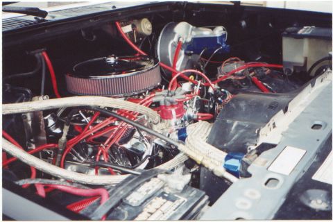 1986 Ford Bronco - The engine bay shows a V8 engine with aftermarket parts, including red spark plug wires and a chrome air cleaner. The brake fluid reservoir…