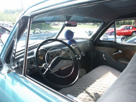 2001 Mercury Grand Marquis - Interior of a classic car with fuzzy dice and a quilted seat, seen at a car show.
