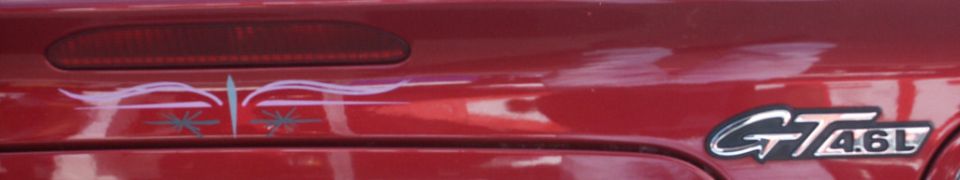 Red car trunk with pinstripe graphics and a chrome GT 4.6L badge