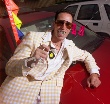 1971 Ford Ranchero - A man in a checkered suit poses with car keys in front of a red vehicle, with another car visible in the background.
