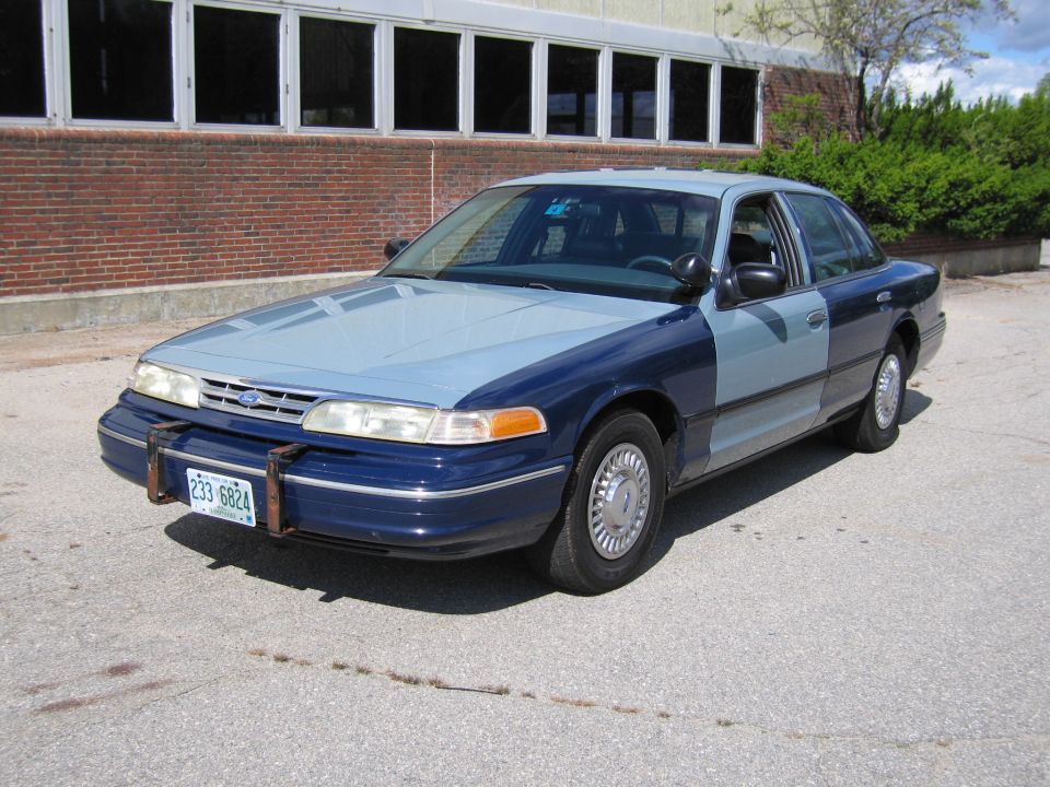 Two-tone blue sedan, 2001 Ford Crown Victoria, with a license plate reading 233-6824