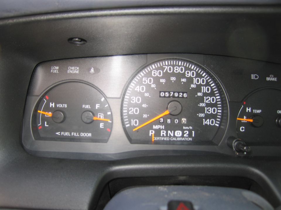 Dashboard gauges showing 57,926 miles, fuel, volts, and temperature. Gear selector is in 'R' (Reverse)