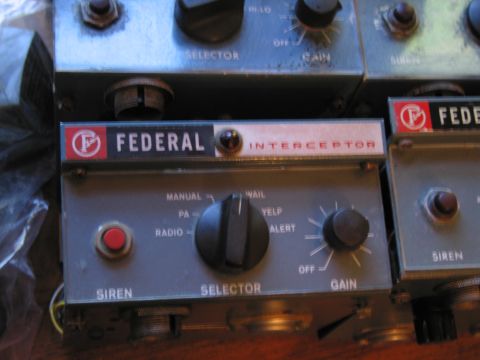 1991 Ford LTD Crown Victoria - Close-up of a single gray Federal Interceptor siren control head showing the red siren button, selector dial and gain knob.