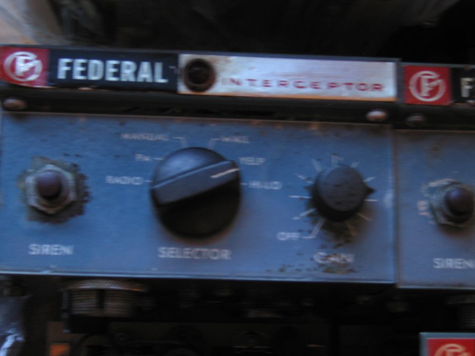 Dimly lit weathered Federal Interceptor siren control panel with knobs