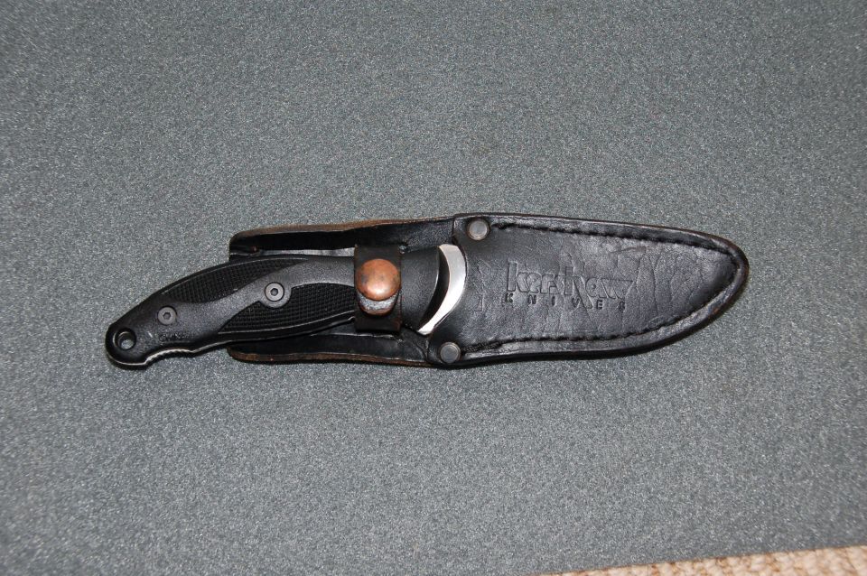 Black Kershaw knife in leather sheath with Kershaw logo