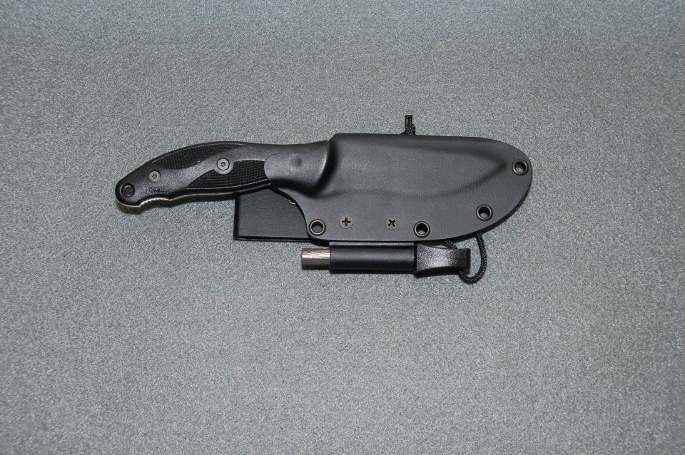 Black fixed-blade knife in a kydex sheath with a firestarter rod
