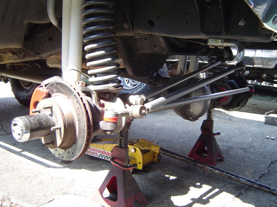 Solid front axle with drilled rotor, coil spring and steering linkage on jack stands