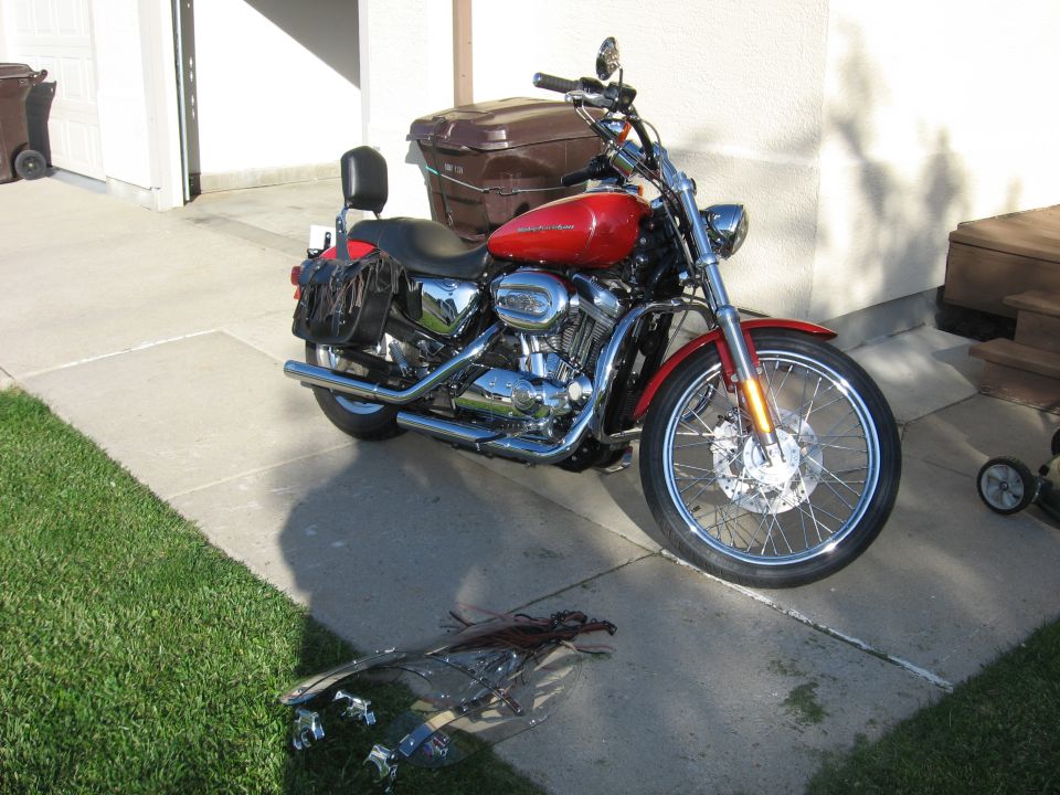 Red Harley-Davidson Sportster motorcycle parked on a driveway.