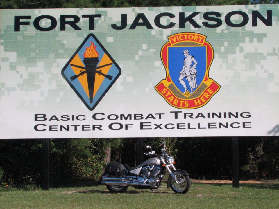 Silver 2006 Victory Kingpin motorcycle parked in front of Fort Jackson Basic Combat Training Center of Excellence sign.