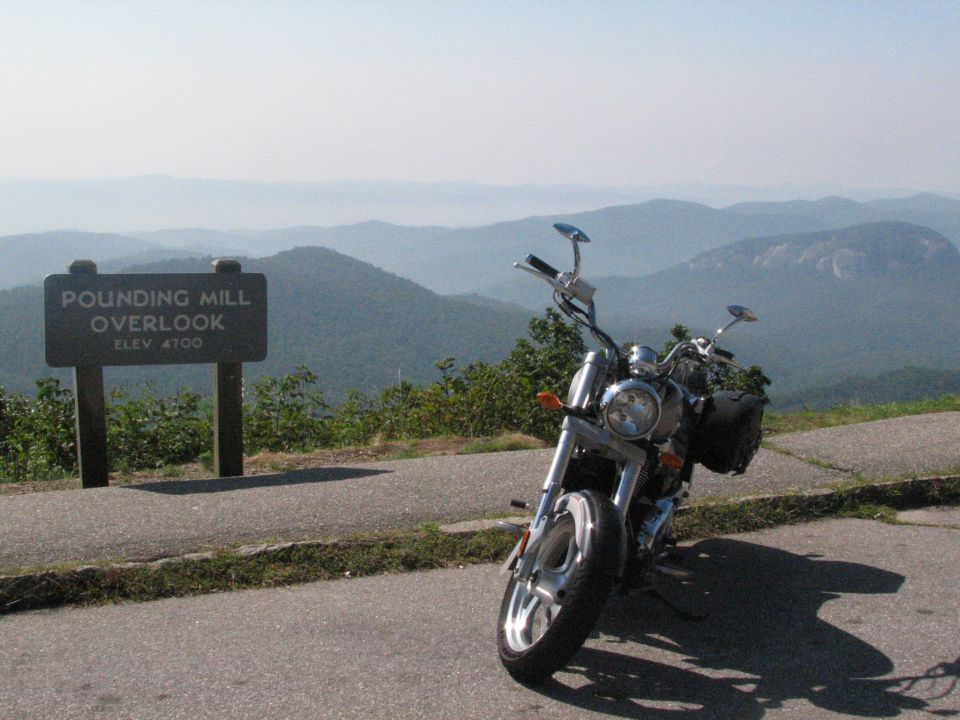 Motorcycle parked at Pounding Mill Overlook with mountain view.