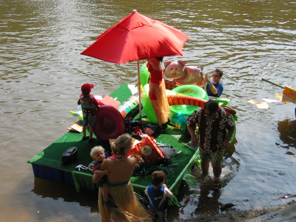 Decorated floating raft with red umbrella and inflatables on a river