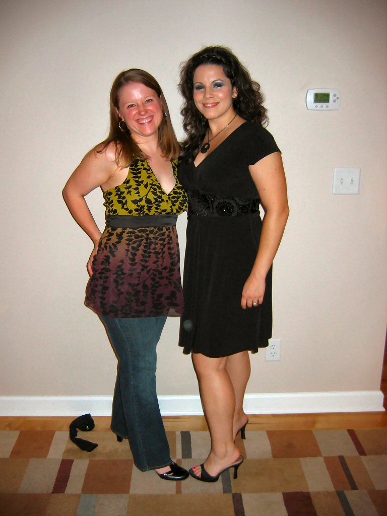 Two women posing on a striped rug in an indoor hallway