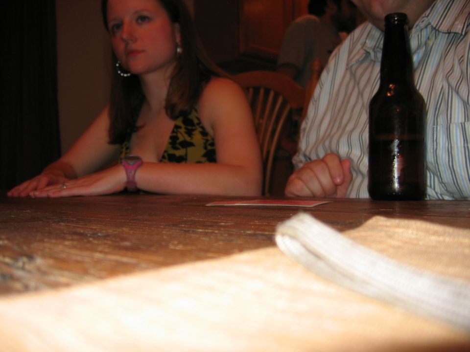 Woman seated at a table with a beer bottle nearby