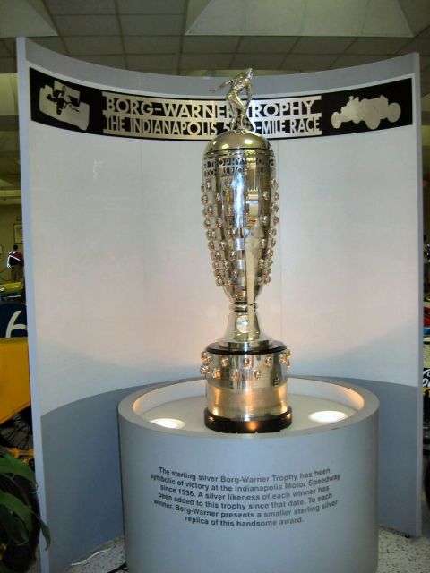 1985 Ford LTD Crown Victoria - Museum photo of the Borg-Warner Trophy display with a descriptive placard, not a technical document.