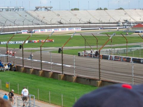 1985 Ford LTD Crown Victoria - Photograph of a racetrack turn and grandstands; not a technical document.